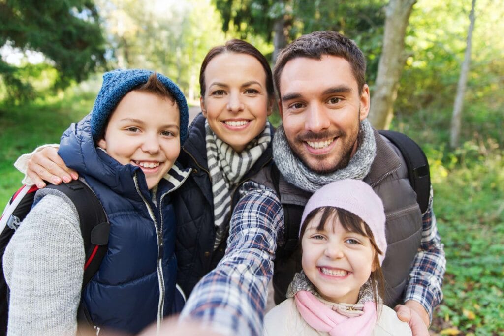 Mother, father, and two children positng for a selfie on a hiking trail