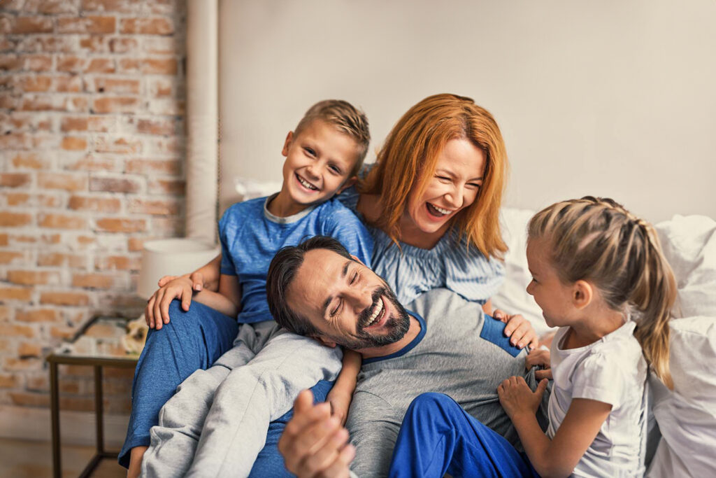 A happy family laughing in their livingroom.