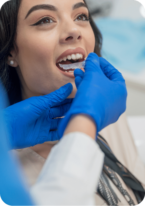 Adult having her Invisalign clear aligner inserted by her orthodontist at her Invsialign appointment