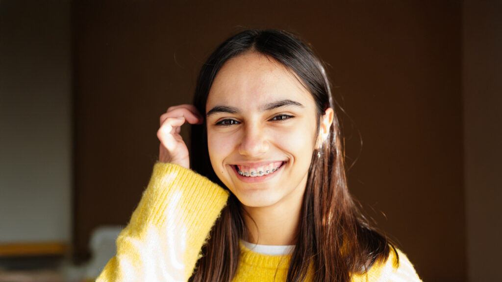 Vibrant teen with braces in New Haven, CT smiling in the afternoon sun