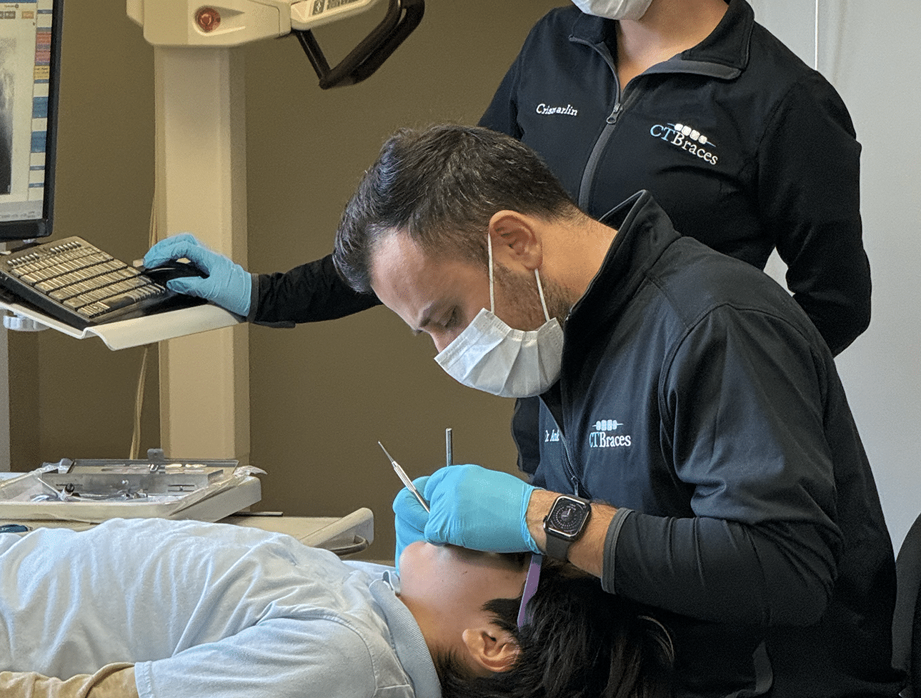 Orthodontist Dr. Fadi Ankah examining a young patient’s braces in CT