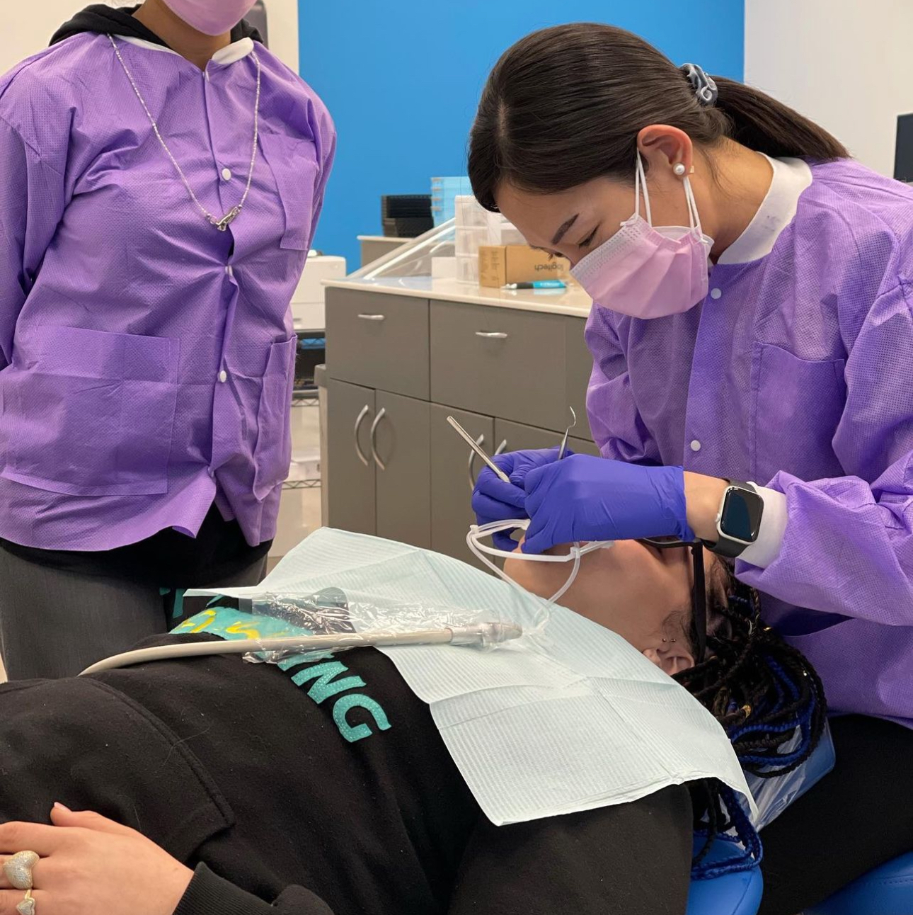 Dr. Lee performing emergency orthodontic treatment on a patient lying down with their eyes closed
